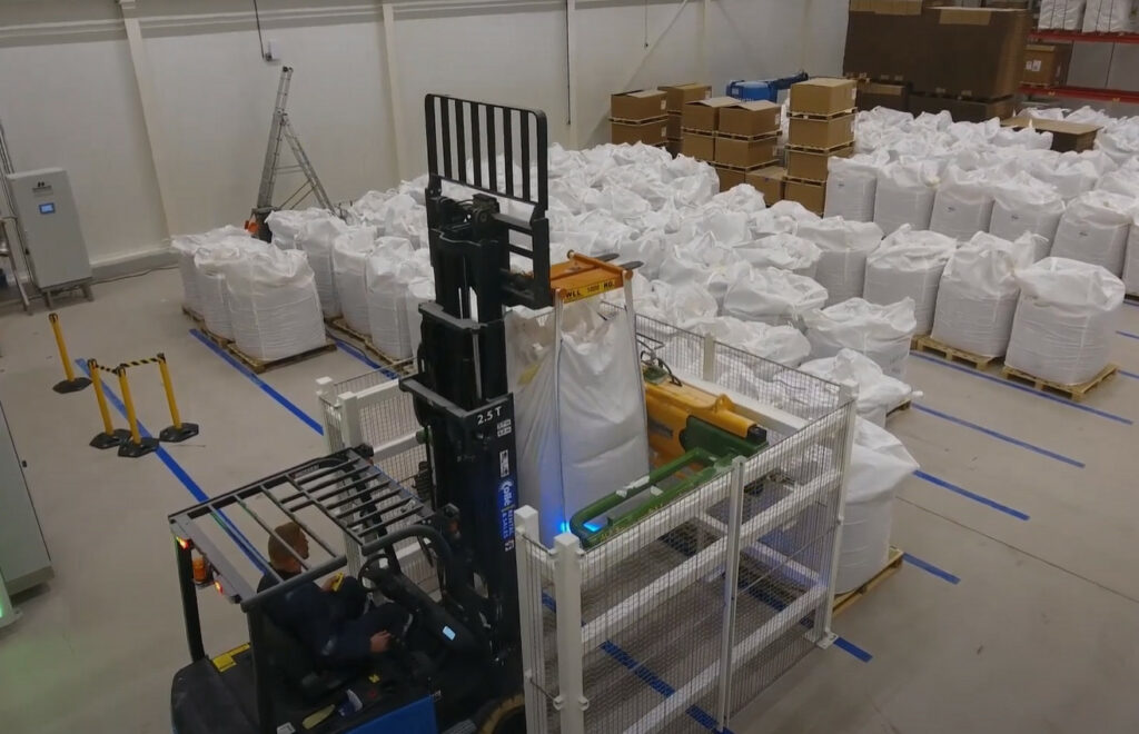 Semi-automatic Bigbag Crusher from Jansen&Heuning processing a bulk bag for efficient material handling.
